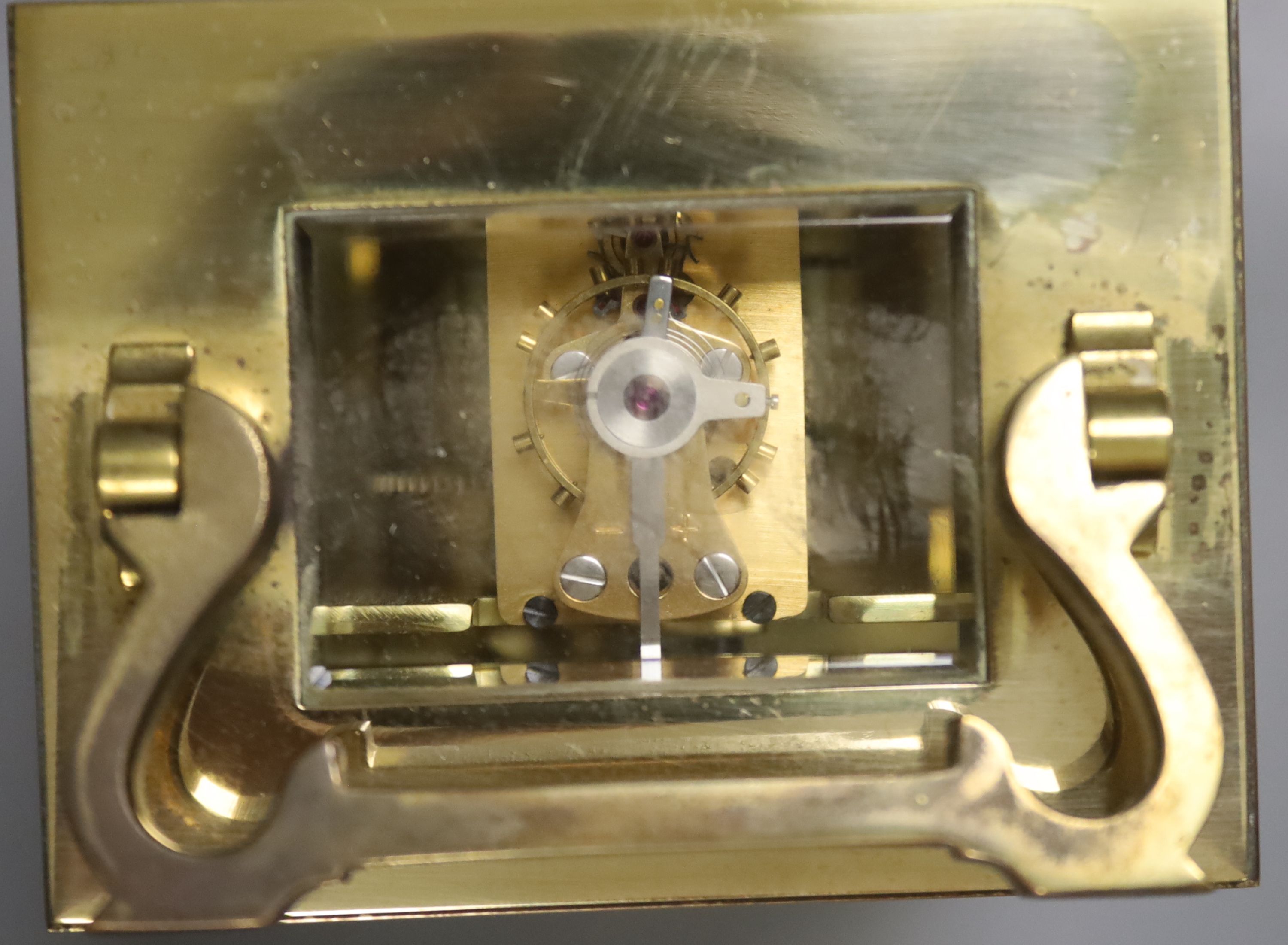 An early 20th century brass carriage timepiece, retailed by Mappin & Webb Ltd, black Roman numerals on a white dial, 8cm wide 15cm high (max.)